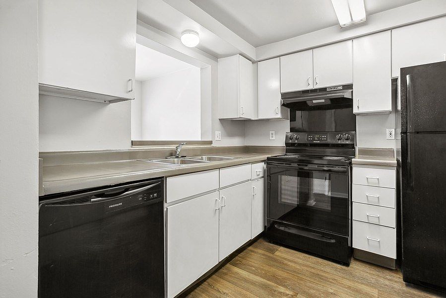 Kitchen with white cabinets and black appliances
