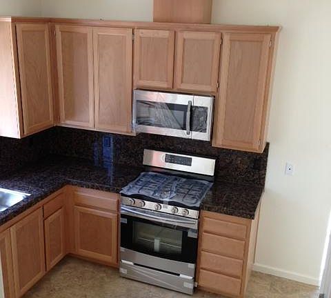 Generous amount of custom built real wood cabinets complemen