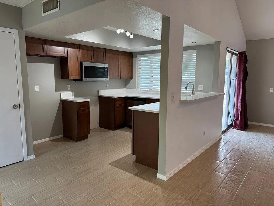 U shaped kitchen with large window looking out on backyard