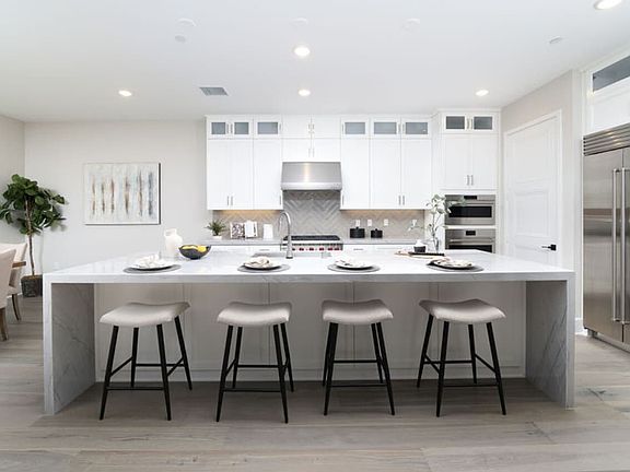 This image showcases the kitchen island with staged furnishings in Villas Homesite 78.