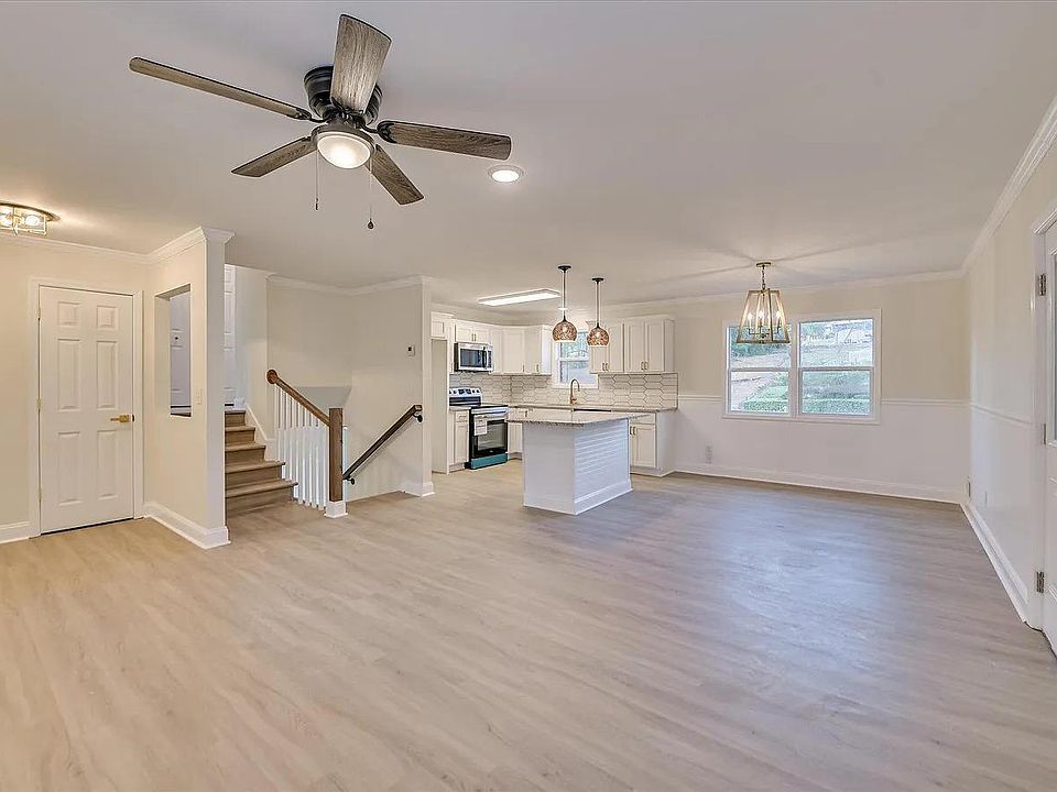 Open-concept main level with spacious living area flowing into an eat-in kitchen with island seating and ample cabinetry.