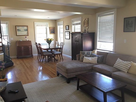Open living dining with many windows and hardwood floors