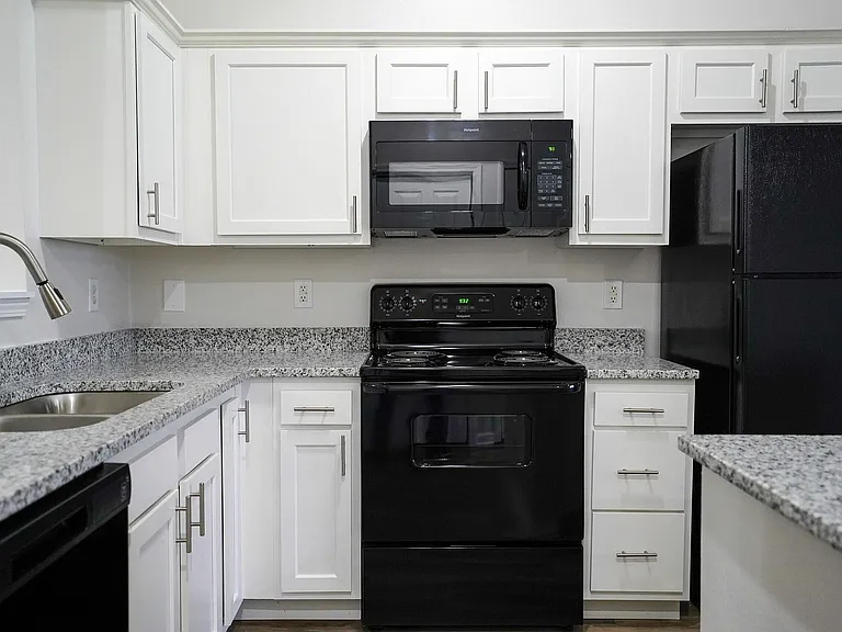 Bright, stylish, and fully equipped _ kitchens at The Bristol Apartments feature white cabinetry, appliances, and plenty of counter space for everyday cooking.