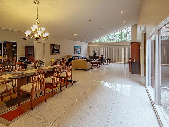 Light and bright dining and living area looks out onto small fenced backyard.