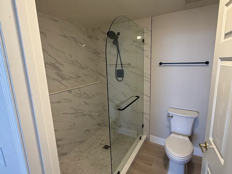 New walk in shower with bench, new toilet, racks, and flooring