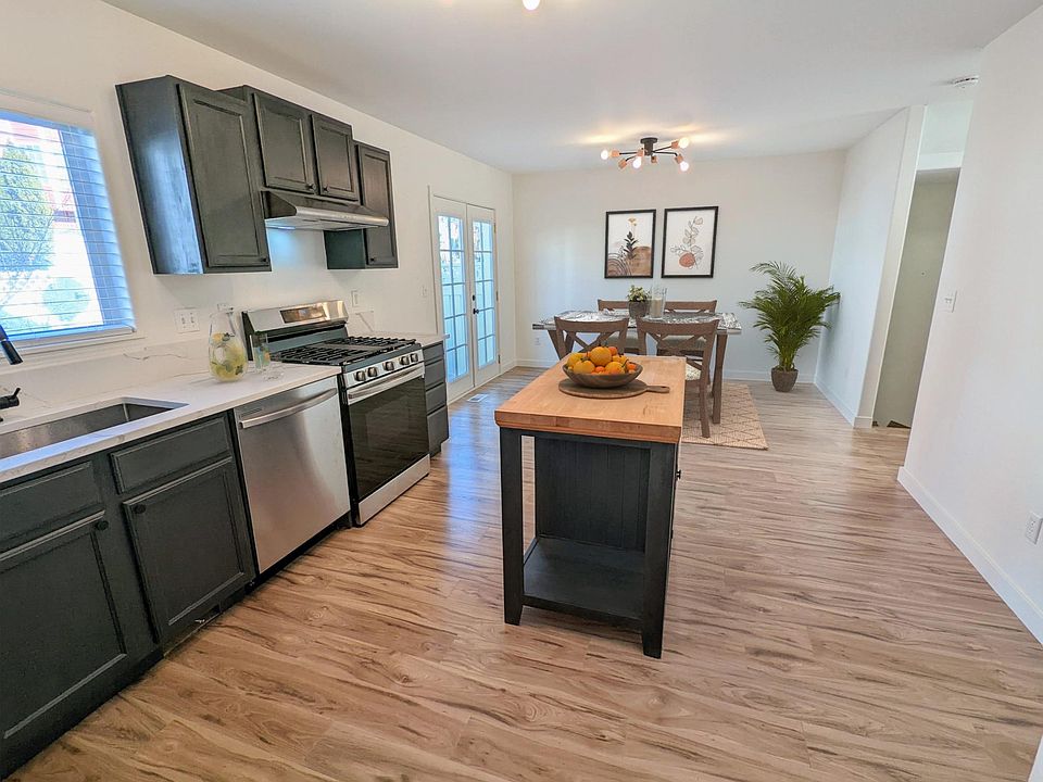 Kitchen with pantry has new countertops, dishwasher, and gas range.