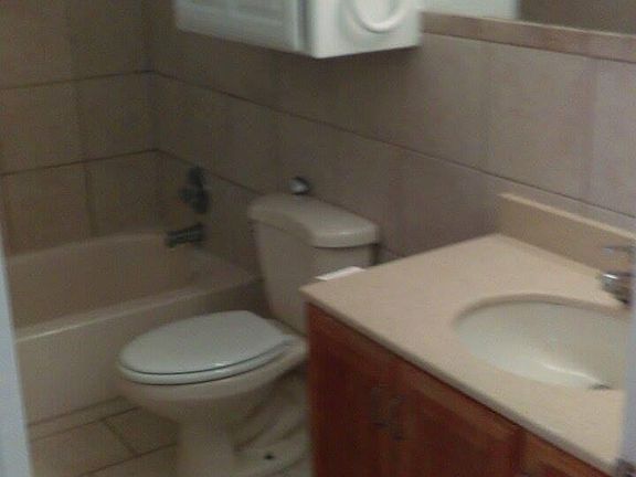 The restroom has an  exhaust vent and tiled flooring 