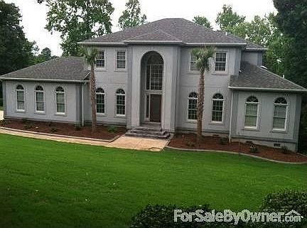 Front Yard View (Daytime)
						:
						Two mature palmetto trees guard the front entrance archway of this elegant home.