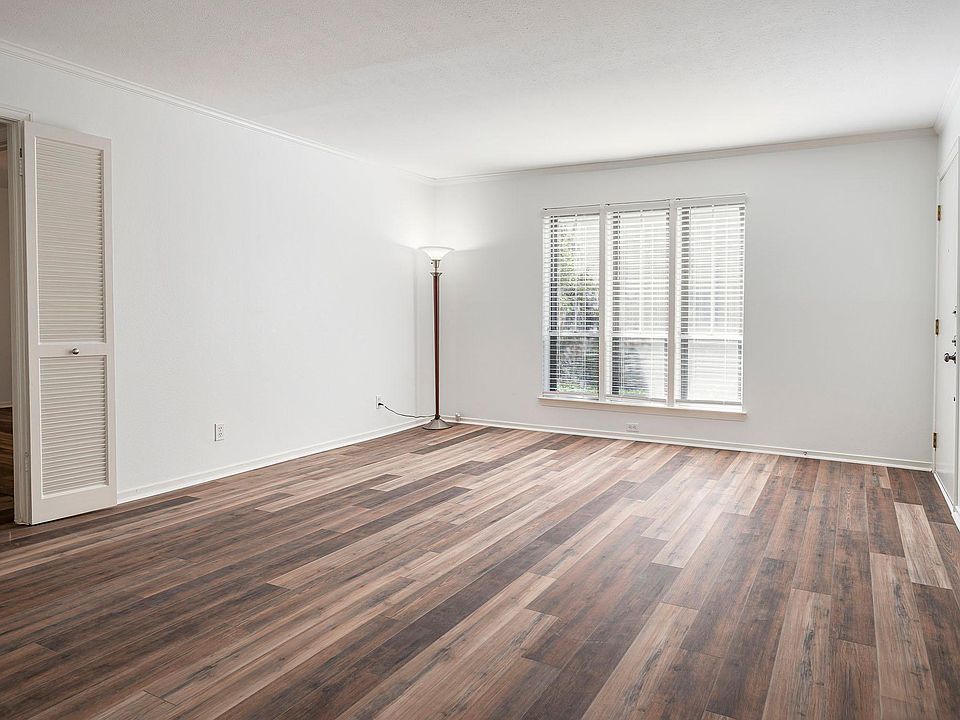 Spacious living room with plenty of natural light, crown molding and engineered hardwood floors.