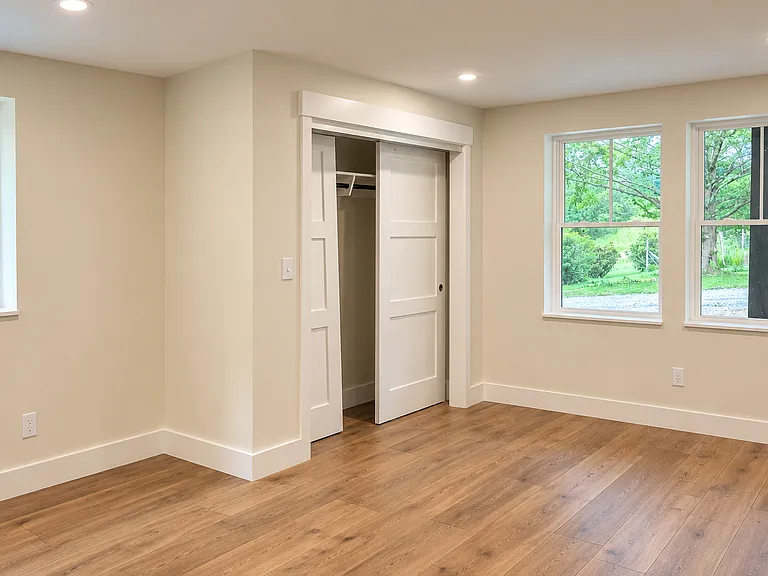 The spacious and bright garden-level primary bedroom features abundant natural light and a serene retreat-like atmosphere.
