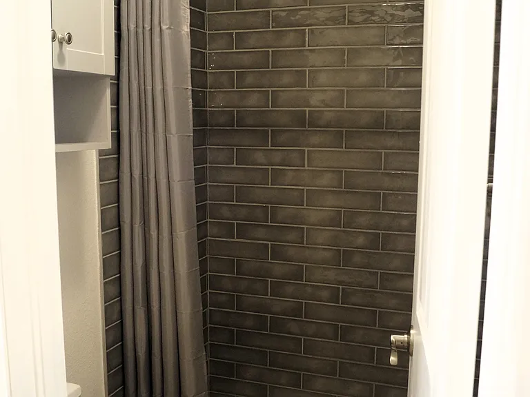 New 3/4 bath in the primary bedroom. 4' tiled shower, water efficient dual flush toilet, storage cabinet and heater/fan/light with a 3-function switch.