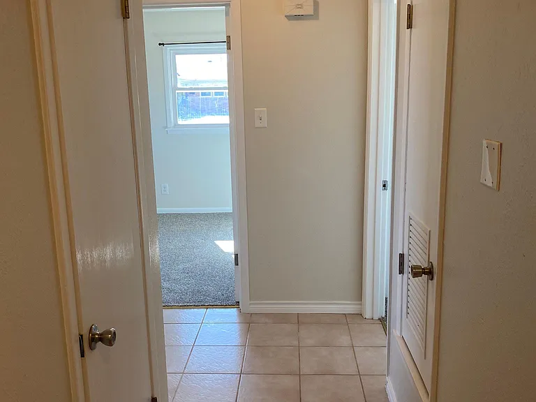 Hallway that connects the 2 secondary bedrooms and main bathroom to the house. Nice size coat closet here also. Custom paint.