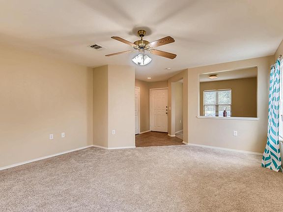 Living area looking to the front door entry way, half bath and study room