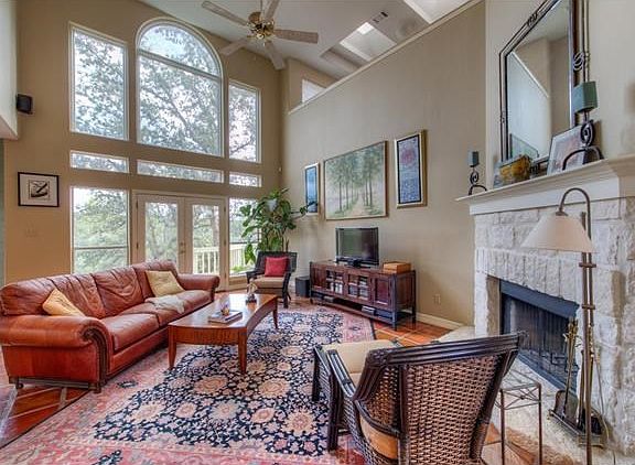 Gorgeous living room with 2-story ceiling, large picture windows, stone fireplace and skylights.