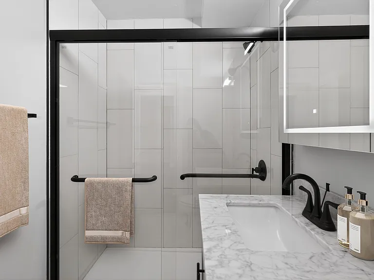 Elevate your living at Eagle Rock Apartments at Woodbury. This stunning, modern bathroom features sleek finishes and a spacious layout, perfect for relaxation. Don't miss out on your ideal homeschedule a tour today!