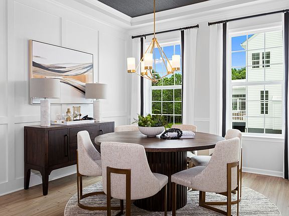 Dining room with 2 large windows tray ceiling in a DRB Homes Aspen II model at the Deerfield Prese