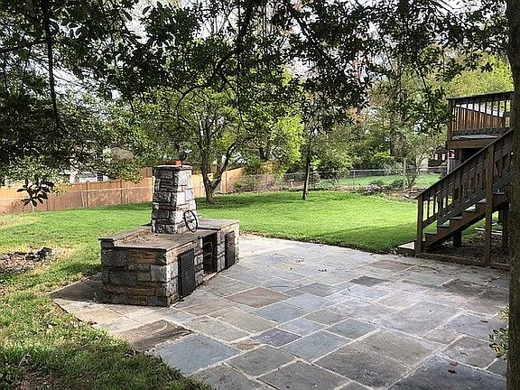 Fenced yard w/stone grill
