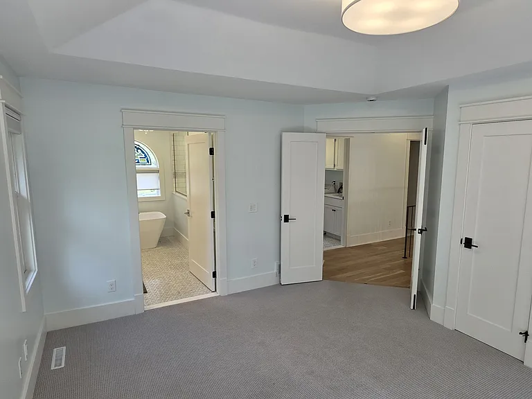 Primary bedroom with private bathroom on left. Double door into bedroom from hallway.