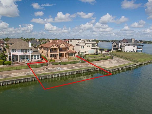 REAR AERIAL HIGHLIGHTS THE LOT OUTLINE WHICH ACTUALLY EXTENDS 100' INTO THE WATER ALLOWING THE OWNER TO BUILD A PIER AND BOATSLIP DIRECTLY BEHIND THE HOUSE. OR ENJOY THE TWO 40' FLOATING SLIPS THAT CONVEY WITH THE HOUSE IN THE CANAL!