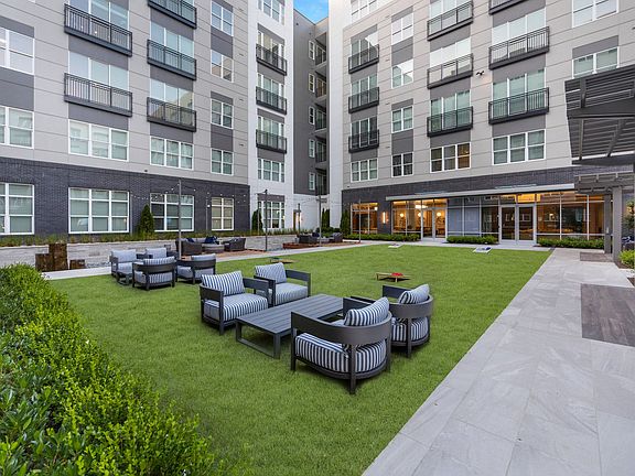 Plentiful green space with outdoor fountain feature, and wood decks with lounge seating