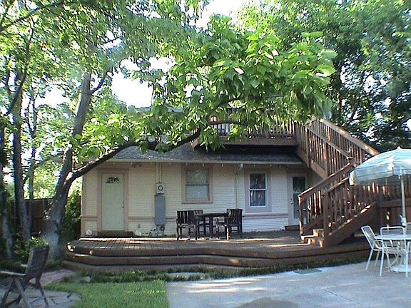 Back view of the house with lower and upper decks and staircase.