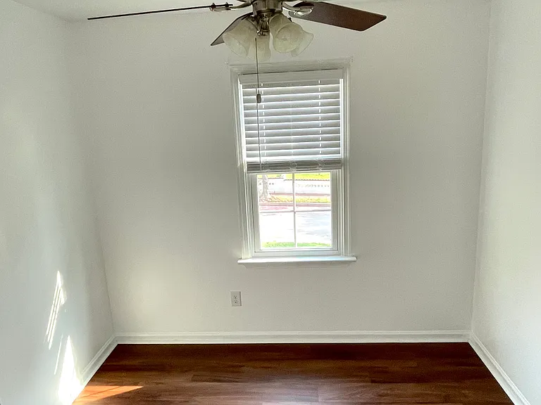 Bedroom 1 with ceiling fan, fresh paint and brand new luxury vinyl flooring.
