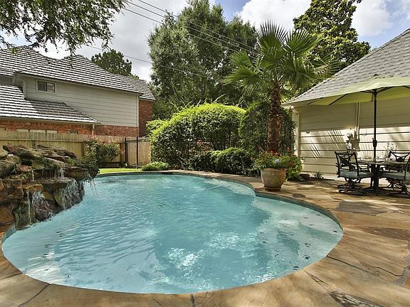 Relax by this sizable pool that is surrounded by flag stone while a rock water feature adds a soothing sound.