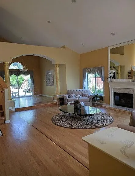 Open floorplan living room with newly polished hardwood floor.