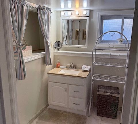 bathroom with mirror and sink storage as well as nook in wall for storage