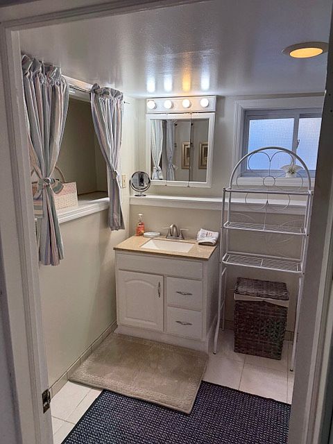 bathroom with mirror and sink storage as well as nook in wall for storage