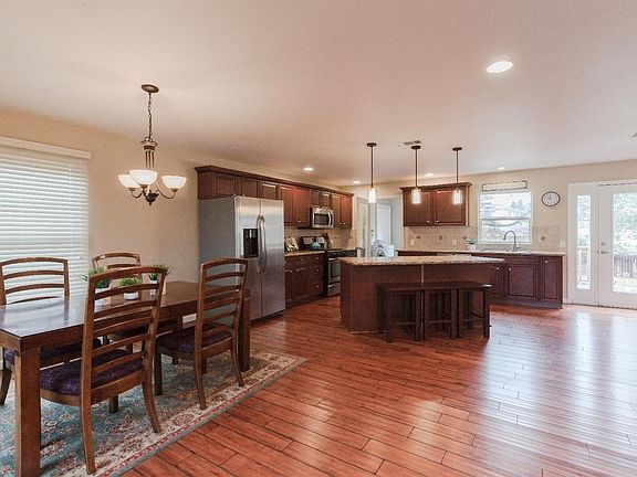 Tasteful pendent lights accent the gorgeous granite and recessed cans fill the home with lovely lighting complimenting the beautiful flooring.