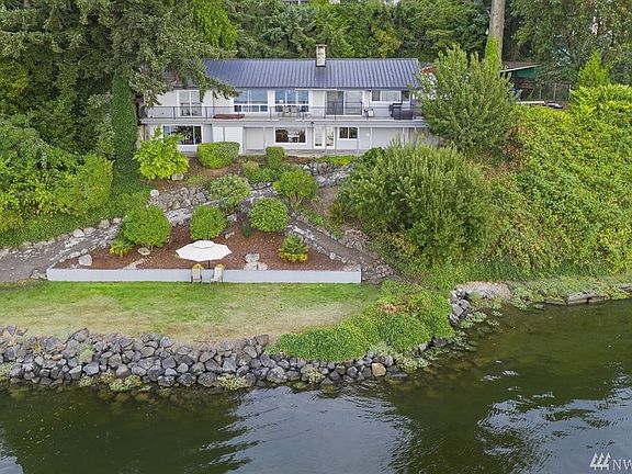 Lounge on the grassy area next to the bulkhead.  Great living off the upper deck, with a sunken hot tub, and from the lower level, the covered porch offers even more outdoor living. Garage on the water side is perfect for storing all of that wet gear for easy water access.  
