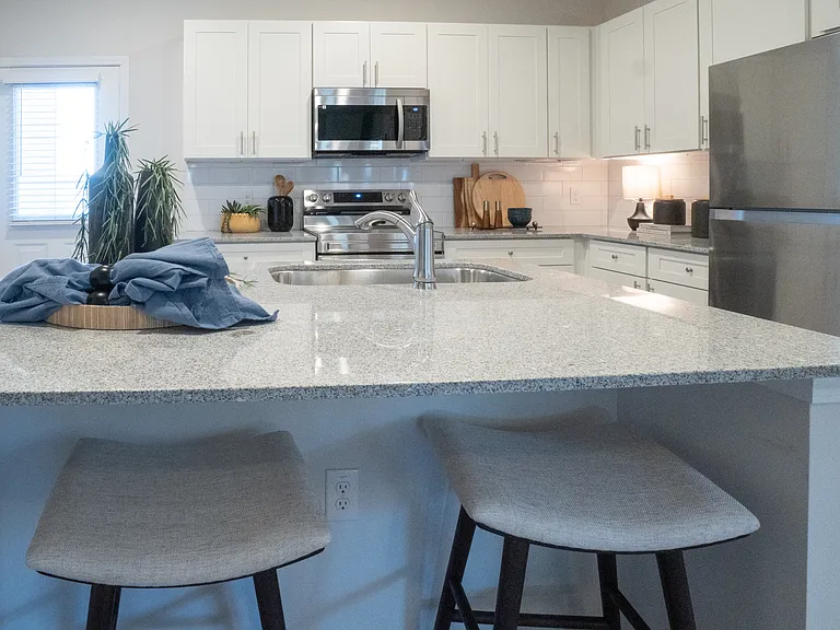 Kitchen island with bar seating, granite countertops and ample countertop space.