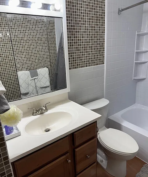 Bath with glass tile walls and large mirror cabinet