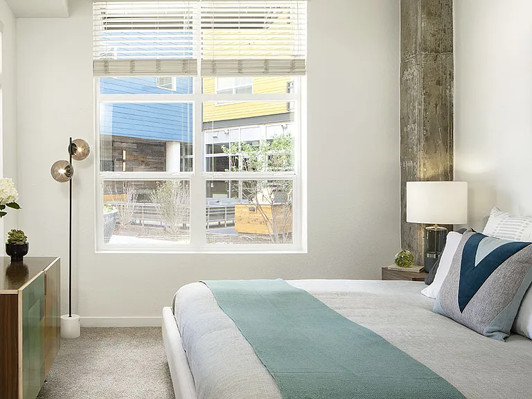 Spacious apartment bedroom with carpeted floors.