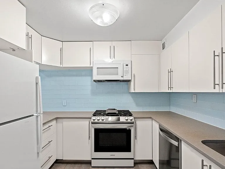 Kitchen with pantry to left of refrigerator
