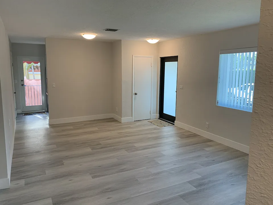 Living Room shown unfurnished (view towards Front Door, Kitchen and Laundry Room)