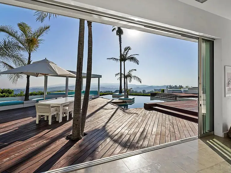Open the glass doors to embrace the perfect harmony of indoor comfort blending effortlessly with the enchanting outdoor setting.
