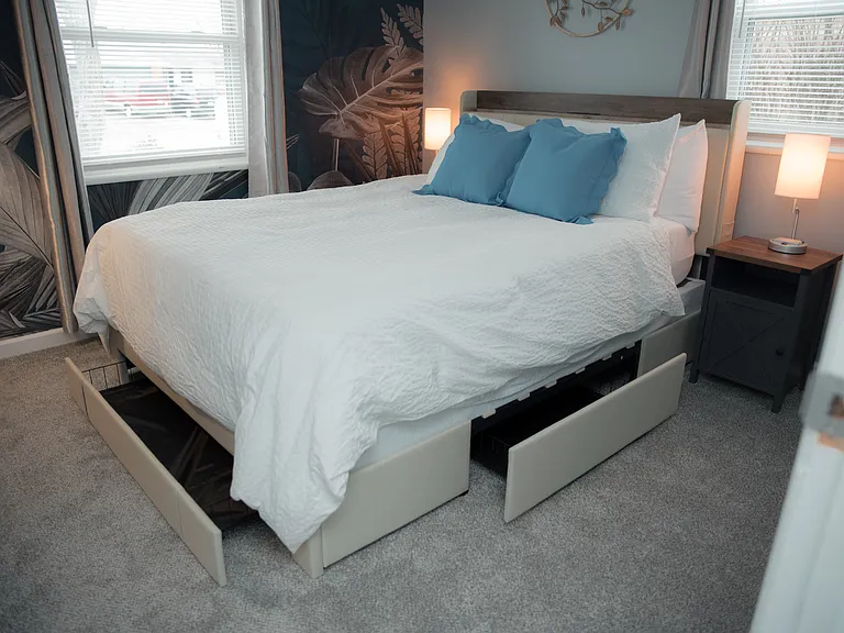 A peaceful retreat featuring a stunning botanical accent wall and a cozy queen-sized bed.