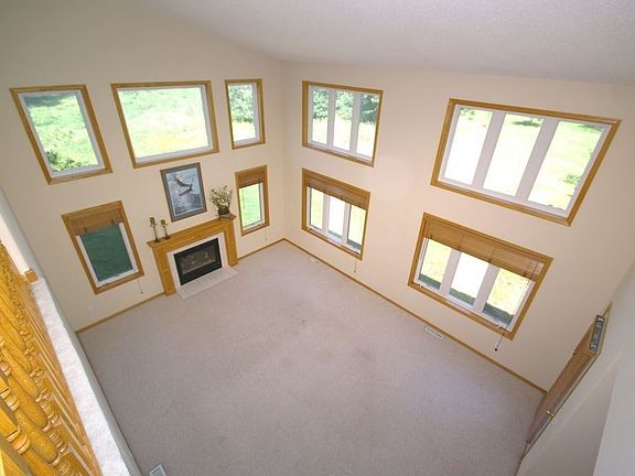 Light filled 2 story Great Room w/walls of windows & gas fireplace.