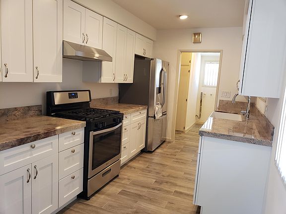 Updated kitchen with stove, refrigerator, granite tops, faucet and farmers sink.