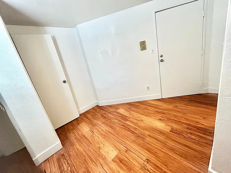Elegant entryway with polished hardwood floors and modern white doors, offering a warm and inviting atmosphere.