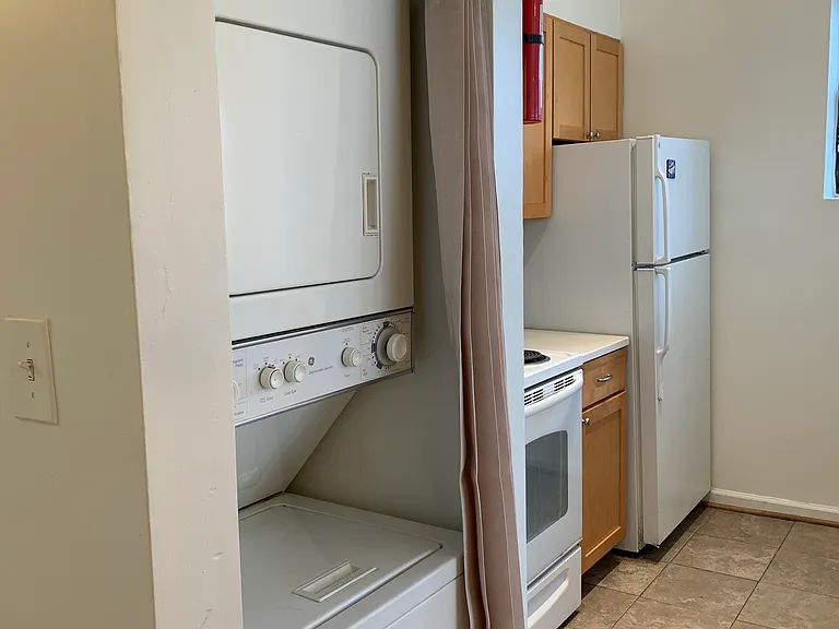 vVew of kitchen and in-unit W/D with closure.