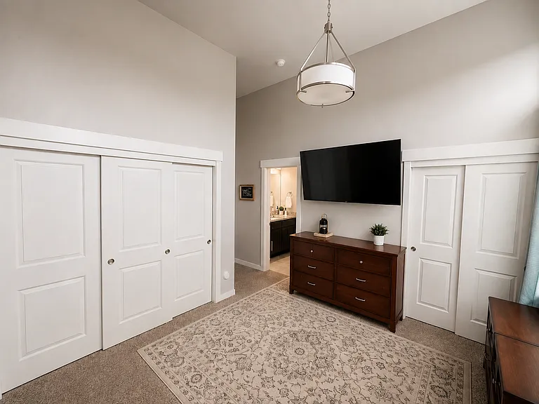 Primary bedroom with high ceiling and two closets.