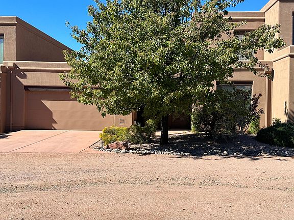 Front of condo with double attached garage, front exterior entry and window in downstairs bedroom.