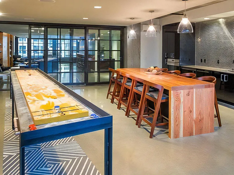 Indoor Resident Lounge with Kitchen, Shuffleboard, and Bar Seating