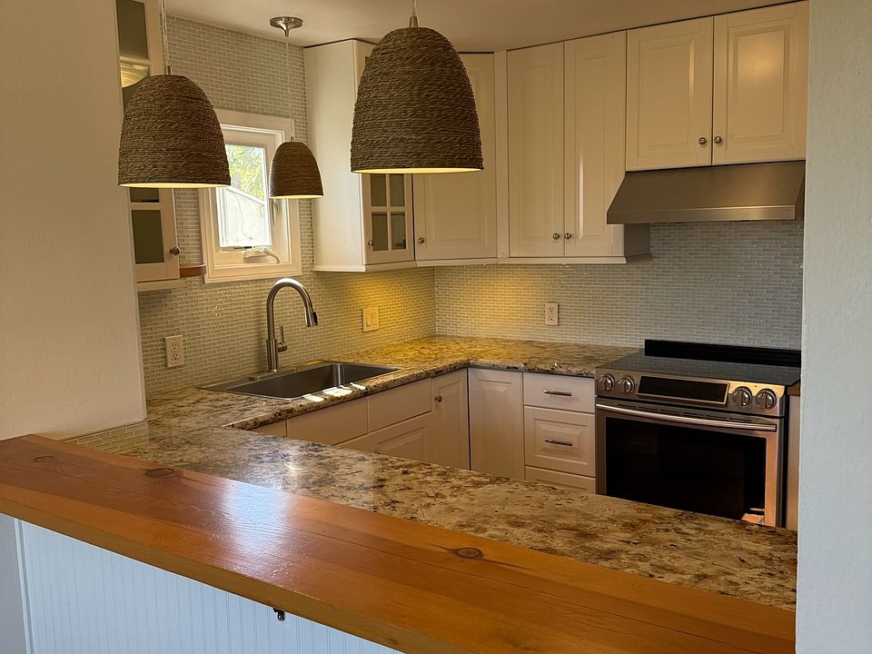 Modern kitchen with granite countertops and stainless steel appliances.