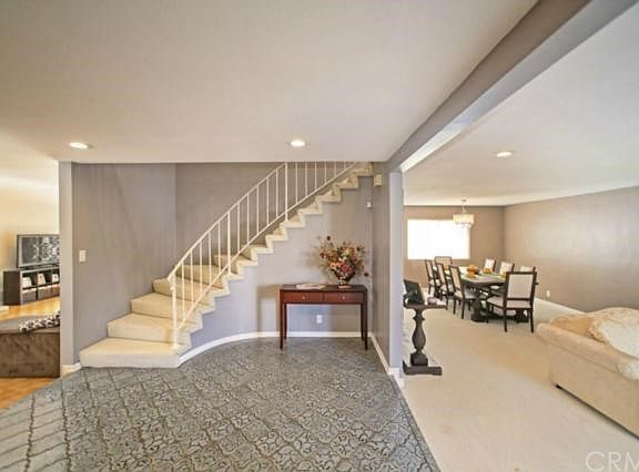 Formal foyer with sweeping staircase - steps down to living & family rooms
