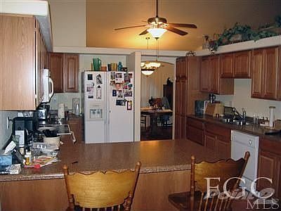 Efficiently designed kitchen with oak cabinets, corian countertops & breakfast bar.