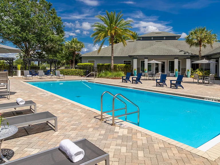 Dive into relaxation at our sparkling resort-style pool, surrounded by plush loungers, shaded seating, and tropical landscaping for a true vacation vibe.